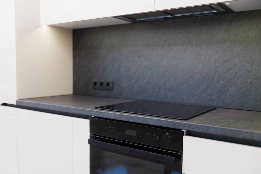 A smooth black cooktop set flush into a slate worktop