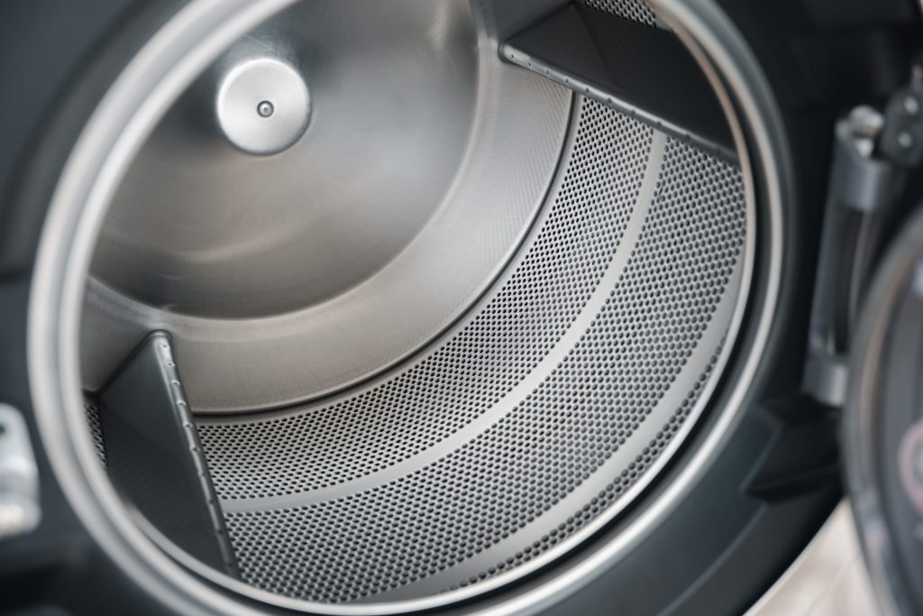 Looking into a dryer drum at the perforated wall and one lifting vane